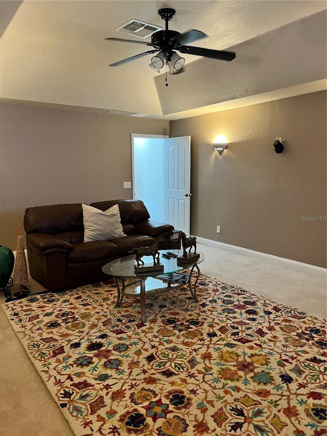 living room featuring ceiling fan, carpet floors, and vaulted ceiling