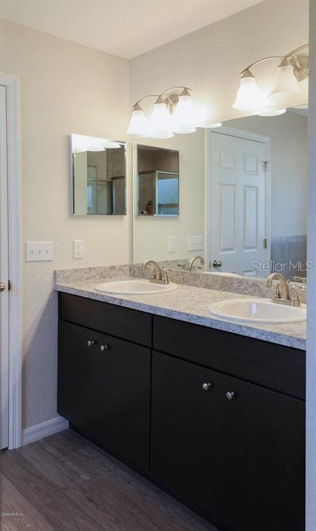 bathroom featuring dual vanity and hardwood / wood-style flooring