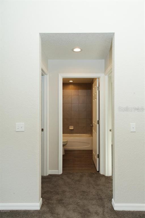 hallway with dark carpet