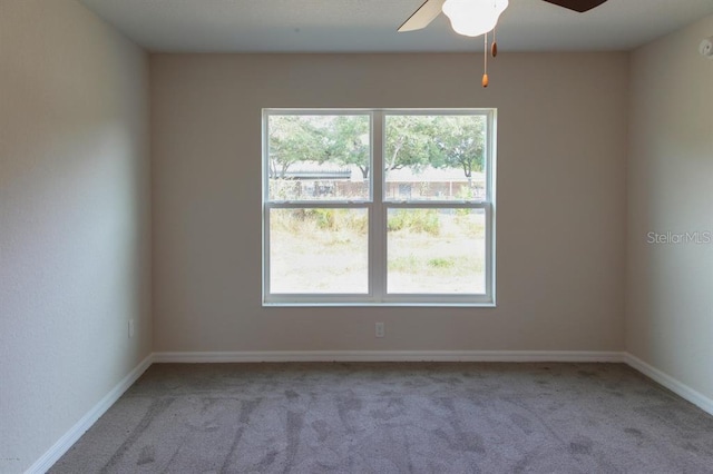 carpeted spare room with a healthy amount of sunlight and ceiling fan