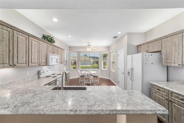 kitchen featuring kitchen peninsula, white appliances, ceiling fan, sink, and wood-type flooring