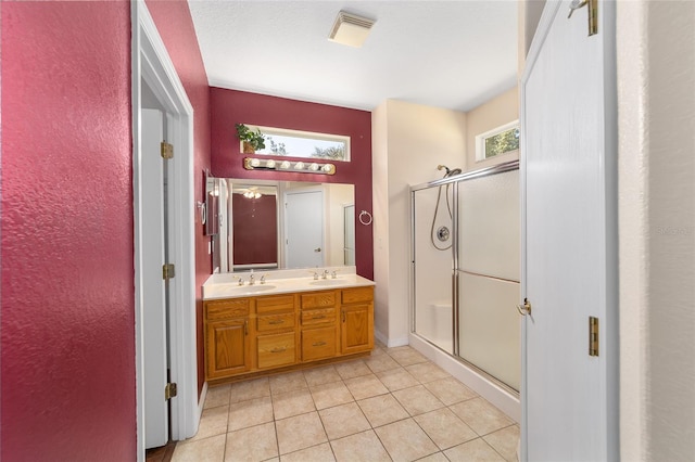 bathroom with a wealth of natural light, tile patterned flooring, vanity, and a shower with door