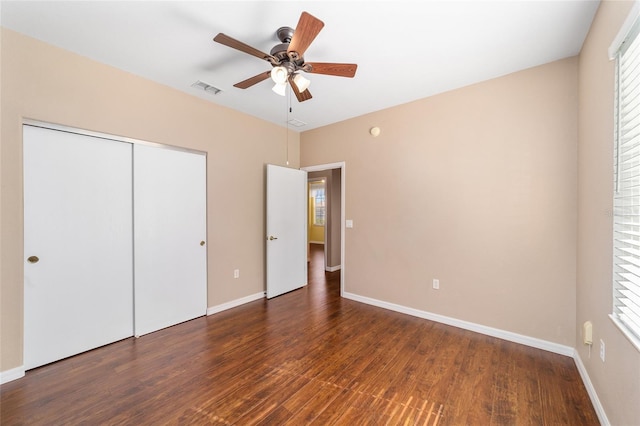 unfurnished bedroom featuring ceiling fan, a closet, and dark hardwood / wood-style floors