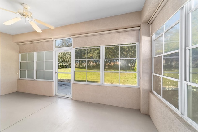 unfurnished sunroom with ceiling fan