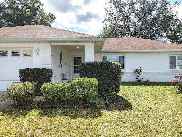 view of front of house with a front yard and a garage