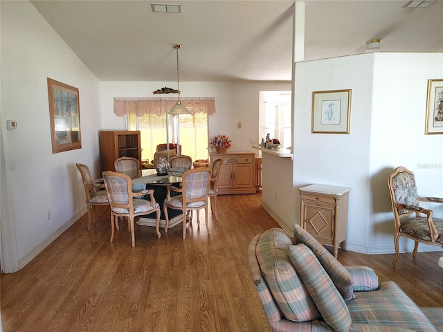 dining area with vaulted ceiling and dark wood-type flooring