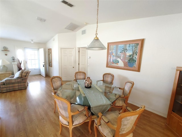 dining area featuring lofted ceiling and light hardwood / wood-style floors