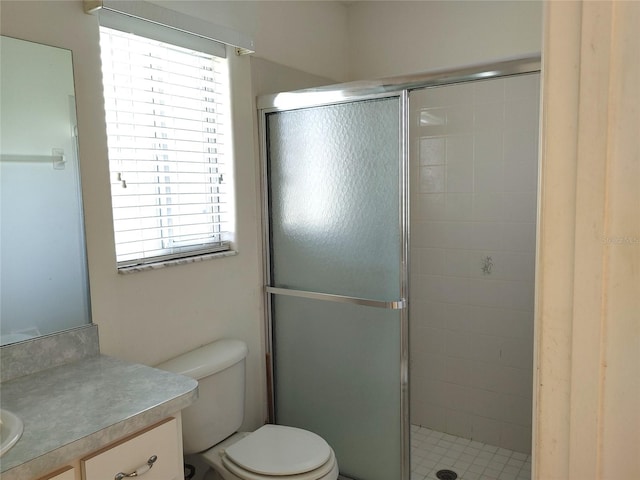 bathroom featuring vanity, plenty of natural light, toilet, and walk in shower