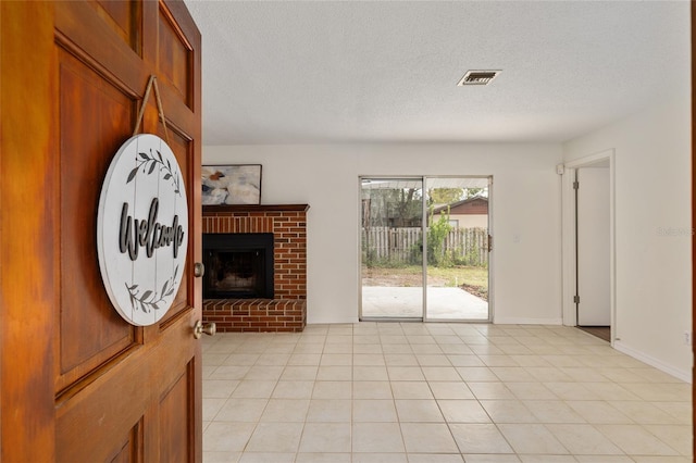 interior space featuring a brick fireplace and a textured ceiling