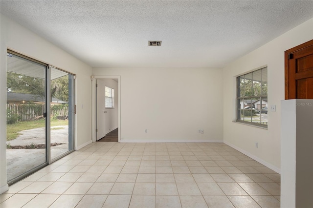 tiled empty room with a textured ceiling