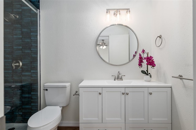 bathroom featuring toilet, vanity, and an enclosed shower