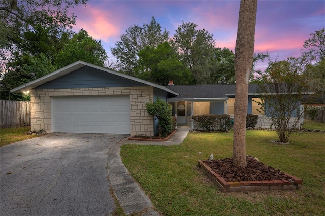 single story home with a garage and a yard