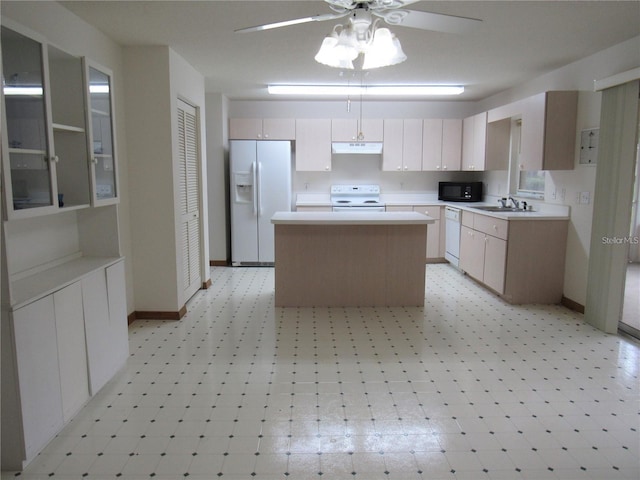 kitchen featuring white appliances, a center island, and light tile flooring