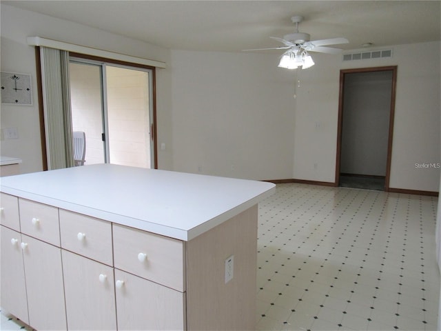 interior space with light tile flooring and ceiling fan