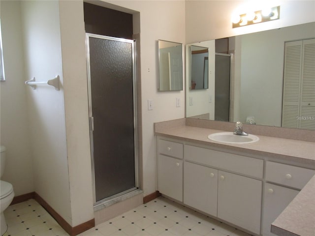 bathroom featuring walk in shower, tile flooring, toilet, and vanity