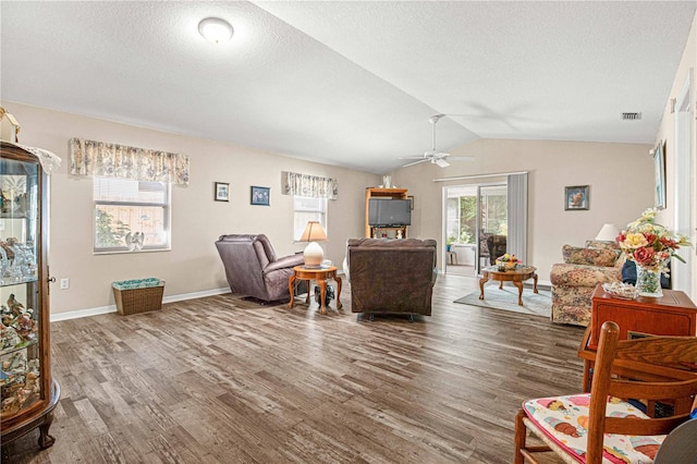 living room with vaulted ceiling, ceiling fan, and dark hardwood / wood-style flooring