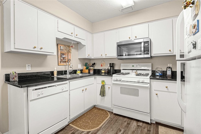 kitchen featuring white appliances, white cabinetry, dark hardwood / wood-style floors, and sink