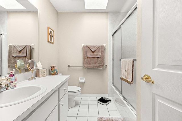 full bathroom with toilet, a skylight, vanity, enclosed tub / shower combo, and tile flooring