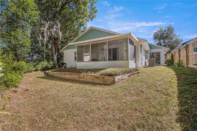 rear view of house with a sunroom and a yard