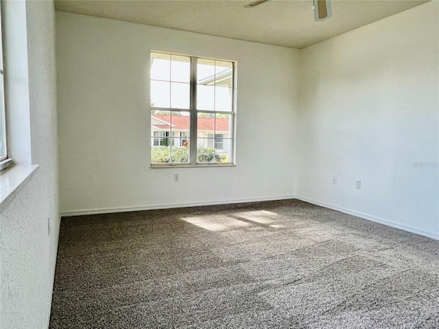 unfurnished room featuring a textured ceiling, carpet flooring, and ceiling fan