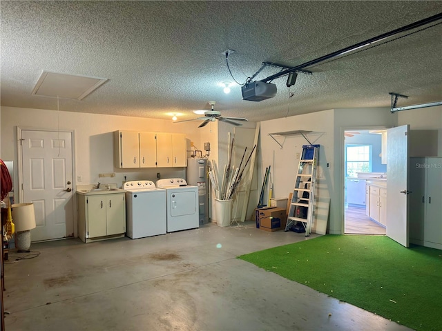 garage featuring electric water heater, independent washer and dryer, sink, a garage door opener, and ceiling fan