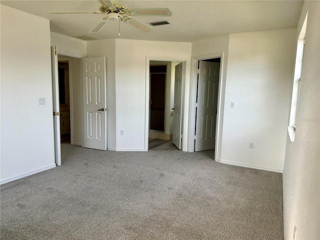 unfurnished bedroom with light carpet, a textured ceiling, and ceiling fan