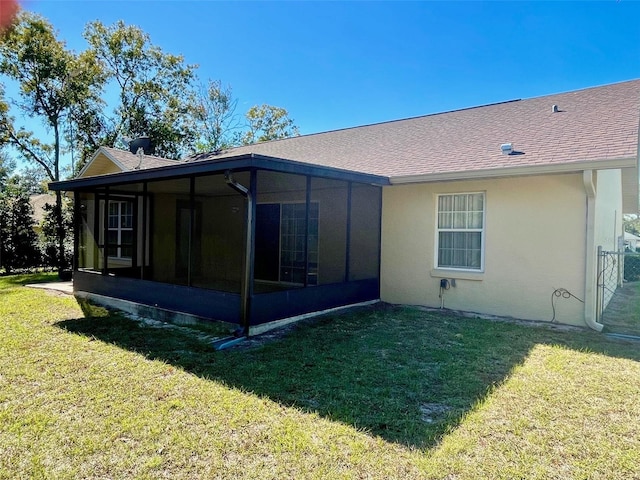 back of property with a yard and a sunroom