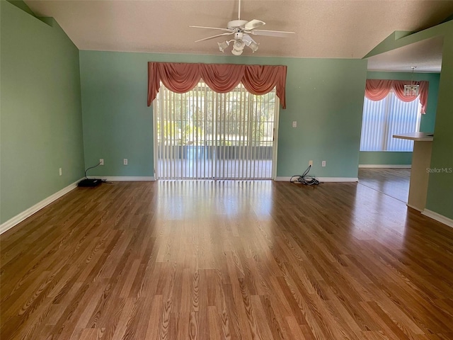 unfurnished room with lofted ceiling, ceiling fan, and wood-type flooring