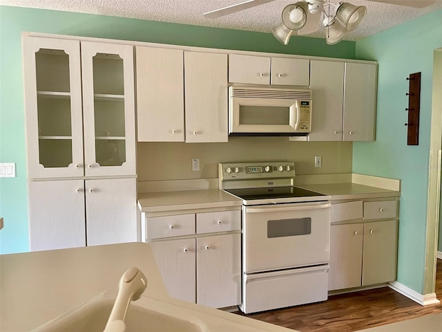 kitchen featuring white appliances, a textured ceiling, ceiling fan, and dark wood-type flooring