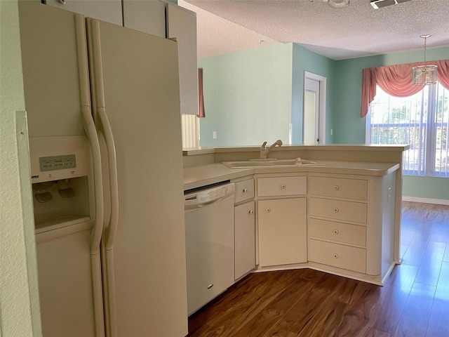 kitchen featuring kitchen peninsula, dark hardwood / wood-style floors, white appliances, sink, and a textured ceiling