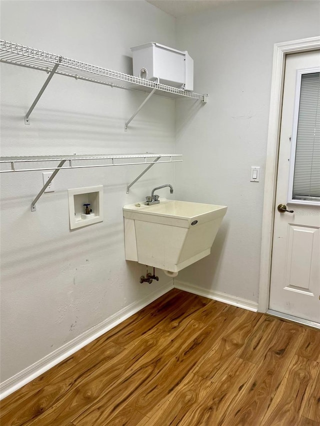 laundry area featuring washer hookup, wood-type flooring, and sink