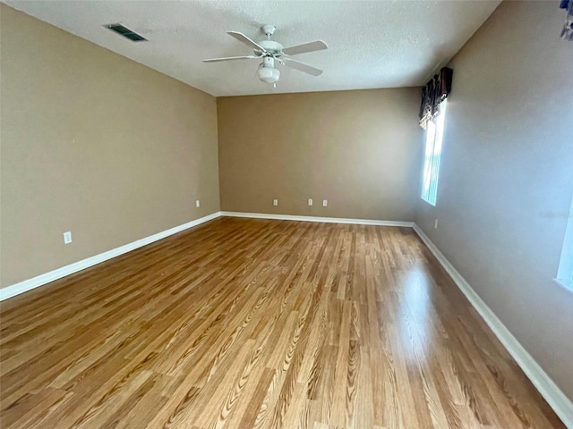 empty room featuring a textured ceiling, ceiling fan, and light wood-type flooring