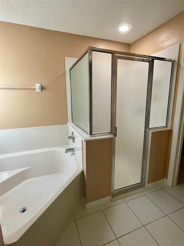 bathroom with a textured ceiling, tile flooring, and plus walk in shower