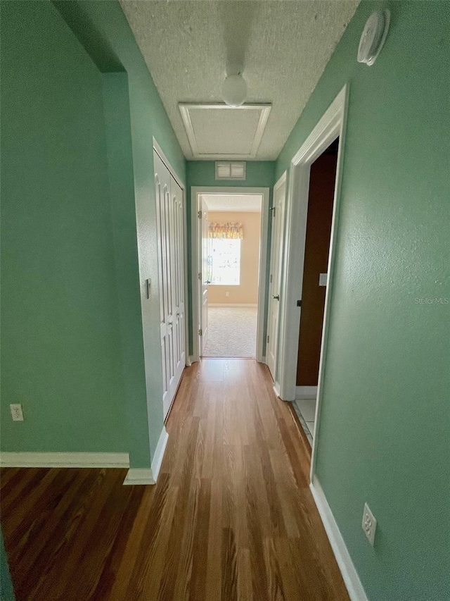 hallway featuring a textured ceiling and dark wood-type flooring