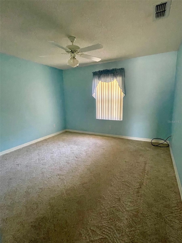 spare room with carpet flooring, a textured ceiling, and ceiling fan