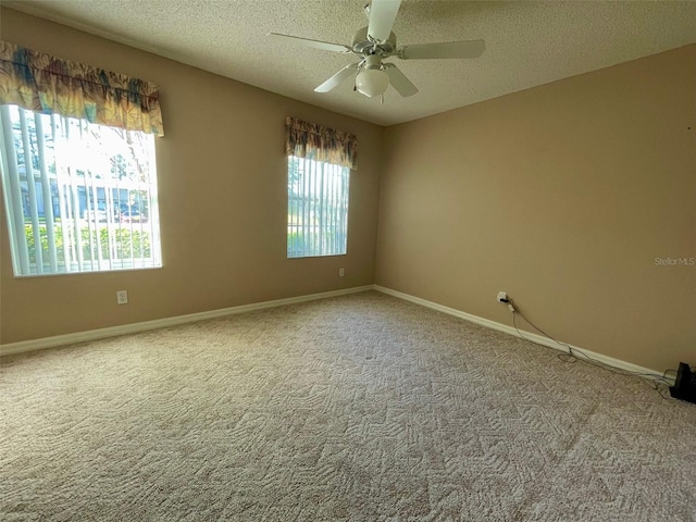 unfurnished room featuring ceiling fan, a textured ceiling, and light colored carpet