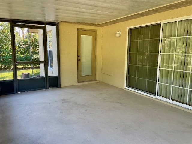 unfurnished sunroom featuring a healthy amount of sunlight and wood ceiling