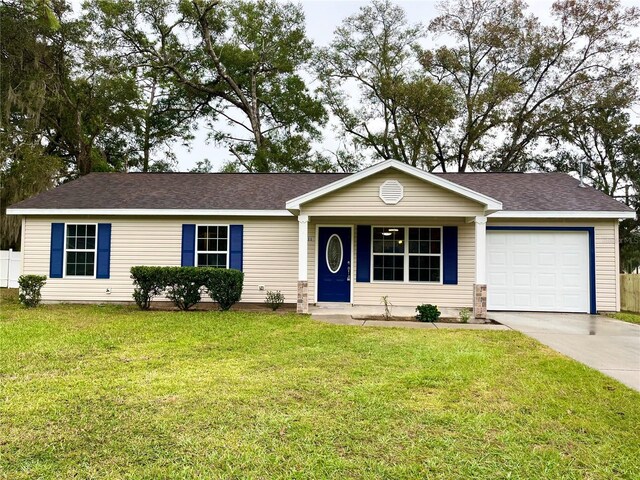 single story home featuring a front lawn and a garage