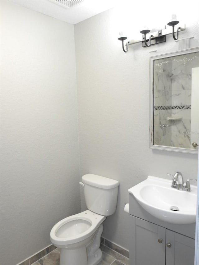 bathroom featuring toilet, tile floors, and vanity