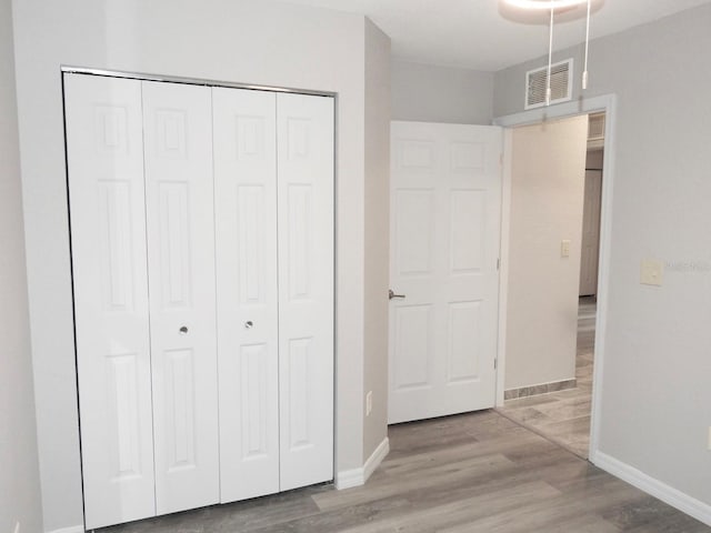 unfurnished bedroom with a closet and light hardwood / wood-style flooring