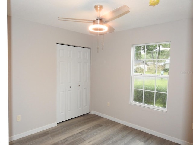 unfurnished bedroom featuring a closet, multiple windows, and light wood-type flooring