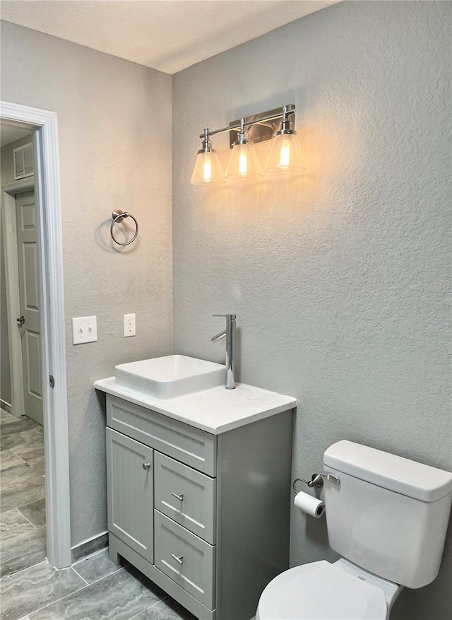 bathroom featuring toilet, tile flooring, and vanity