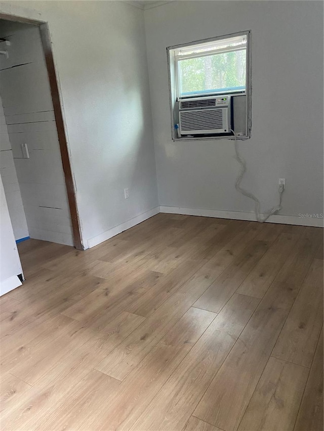 unfurnished room with cooling unit and light hardwood / wood-style flooring