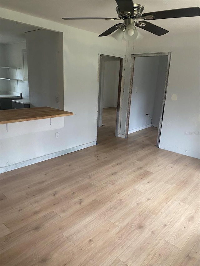 unfurnished living room featuring ceiling fan and light hardwood / wood-style floors