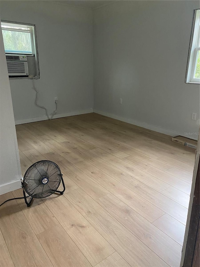 unfurnished room with cooling unit and light hardwood / wood-style floors