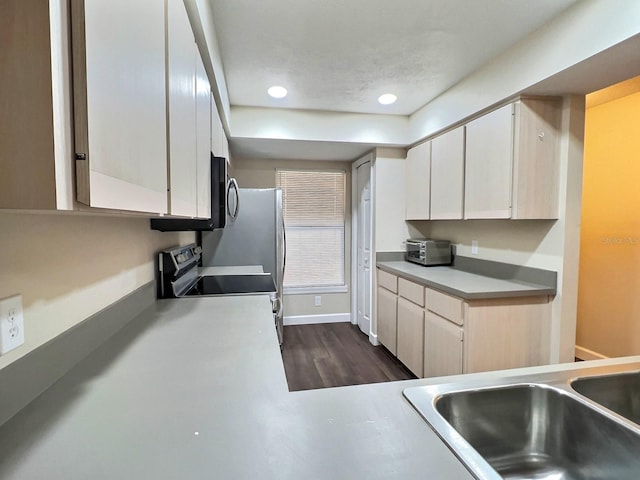 kitchen with dark hardwood / wood-style flooring, range, white cabinets, and sink