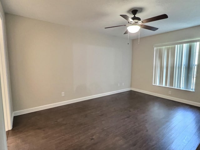 unfurnished room featuring dark wood-type flooring and ceiling fan