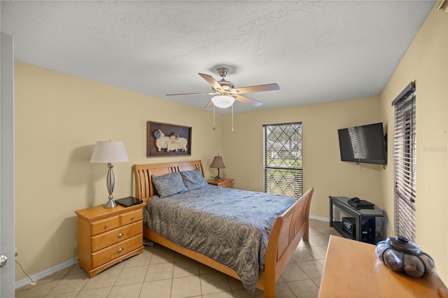 bedroom with a textured ceiling, ceiling fan, and light tile floors