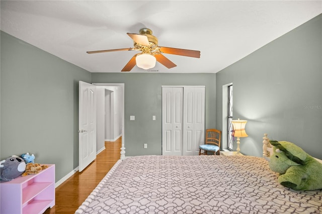 bedroom featuring ceiling fan, a closet, and dark wood-type flooring