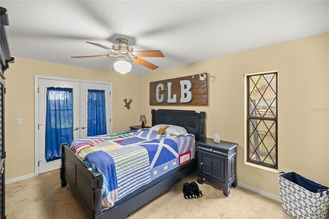 carpeted bedroom with french doors, a textured ceiling, and ceiling fan